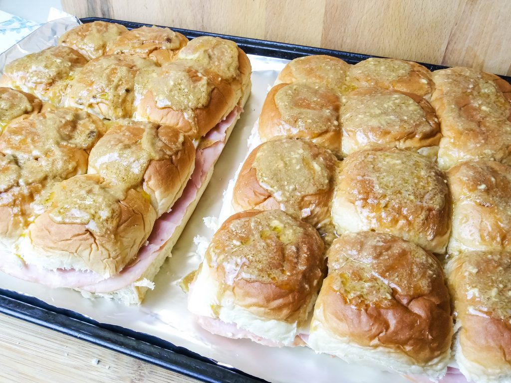 two sets of ham and cheese sliders on cookie sheet 