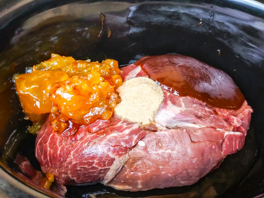 all the ingredients in the slow cooker with the beef roast
