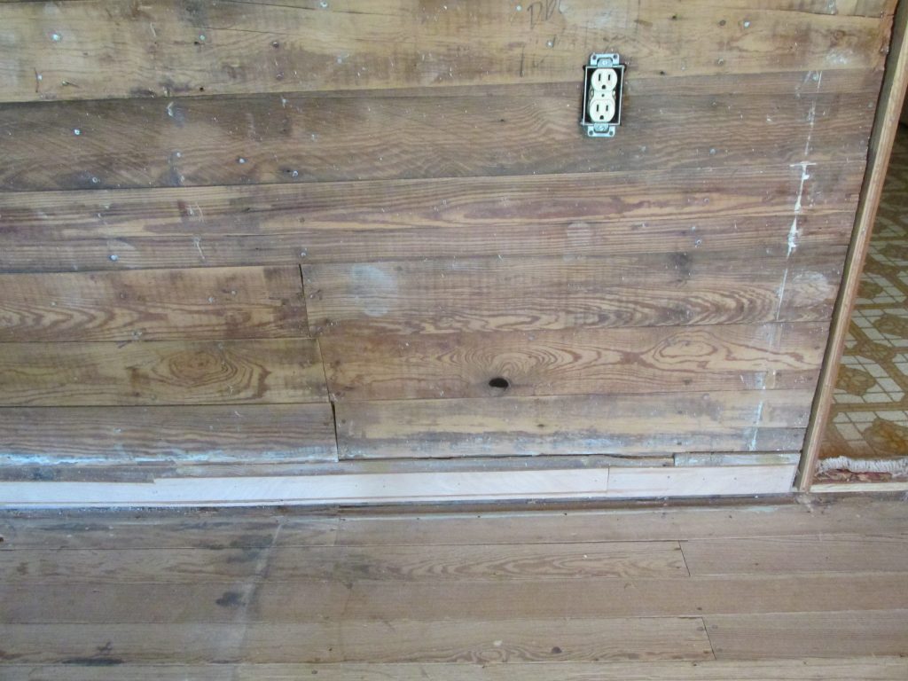 knot hole in lower part of wall near the floor