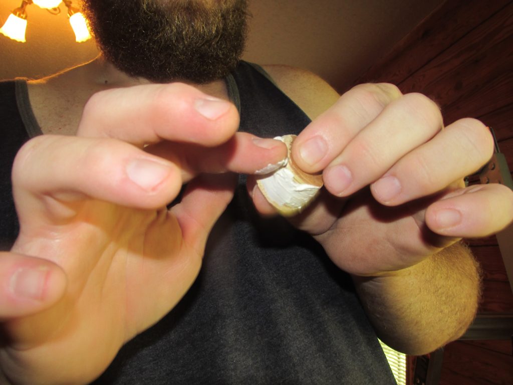 man smearing glue on knot hole plug
